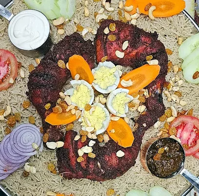 Rice platter with masala fried chicken, boiled eggs, cashews, raisins, raita and salan at Bawarchi in Mississauga